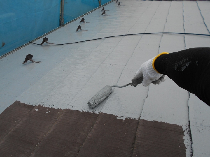 屋根塗装です。塗装に入る前に既存の亀裂箇所はガルバリウム鋼板の差込み工法で強化しました。こちらは1回目（下塗り）の塗装です。下塗り塗料は接着剤のような役割を果たし、より塗料の密着性を高める機能があるため、下塗りが不十分の場合、塗装が剥がれやすくなってしまいます。