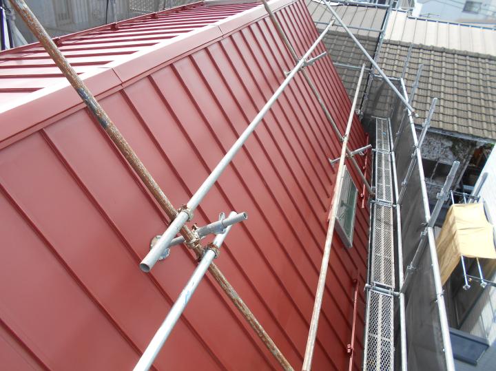 屋根はガルバリウム鋼板立平葺きです。鋼板自体は25年腐食しないと云われておりますが、塗装が劣化しているので２液型屋根用エポキシ樹脂錆止で密着性を高めてから仕上げ塗りを行います。